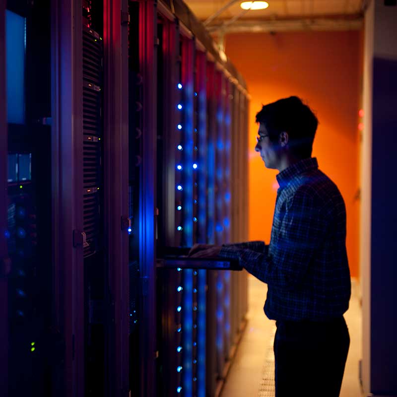 A man working in a server farm A man working in a server farm