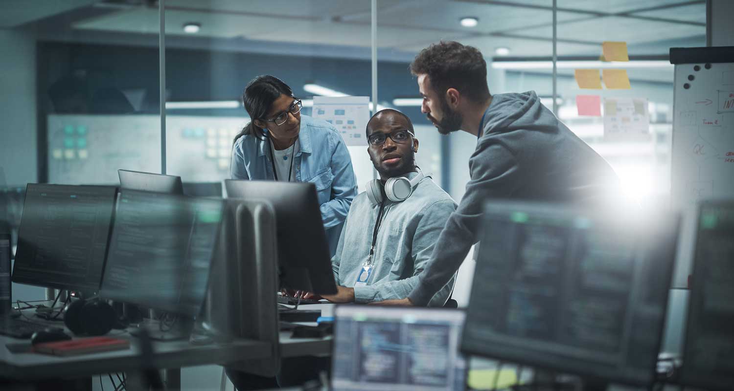 Three people working at a computer