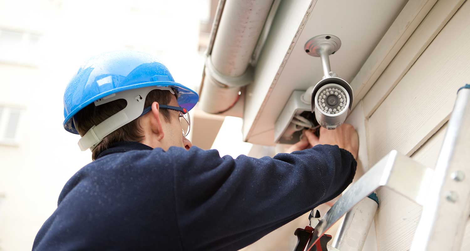 A camera installer working on an exterior camera